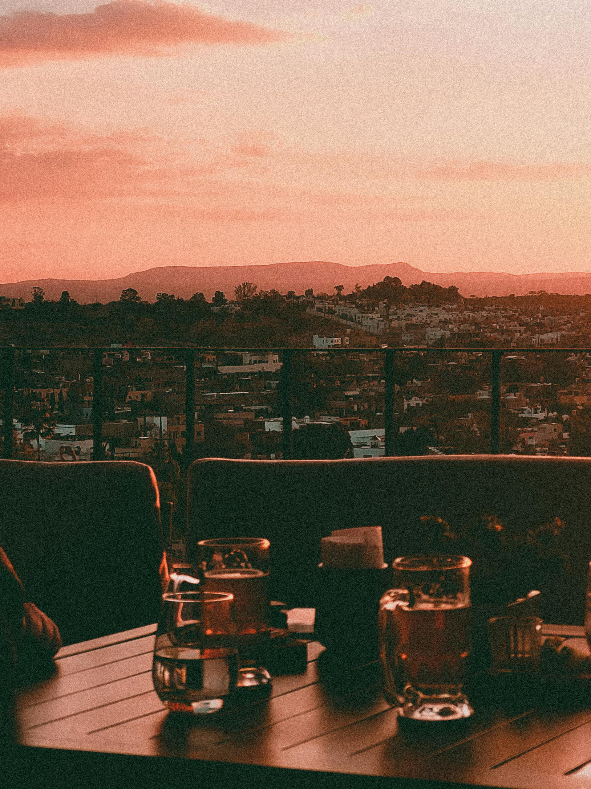 Capture the vibrant sunset over San Miguel de Allende from a rooftop terrace with drinks.